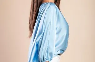 Blusa elegante con scollo asimmetrico, di colore azzurro